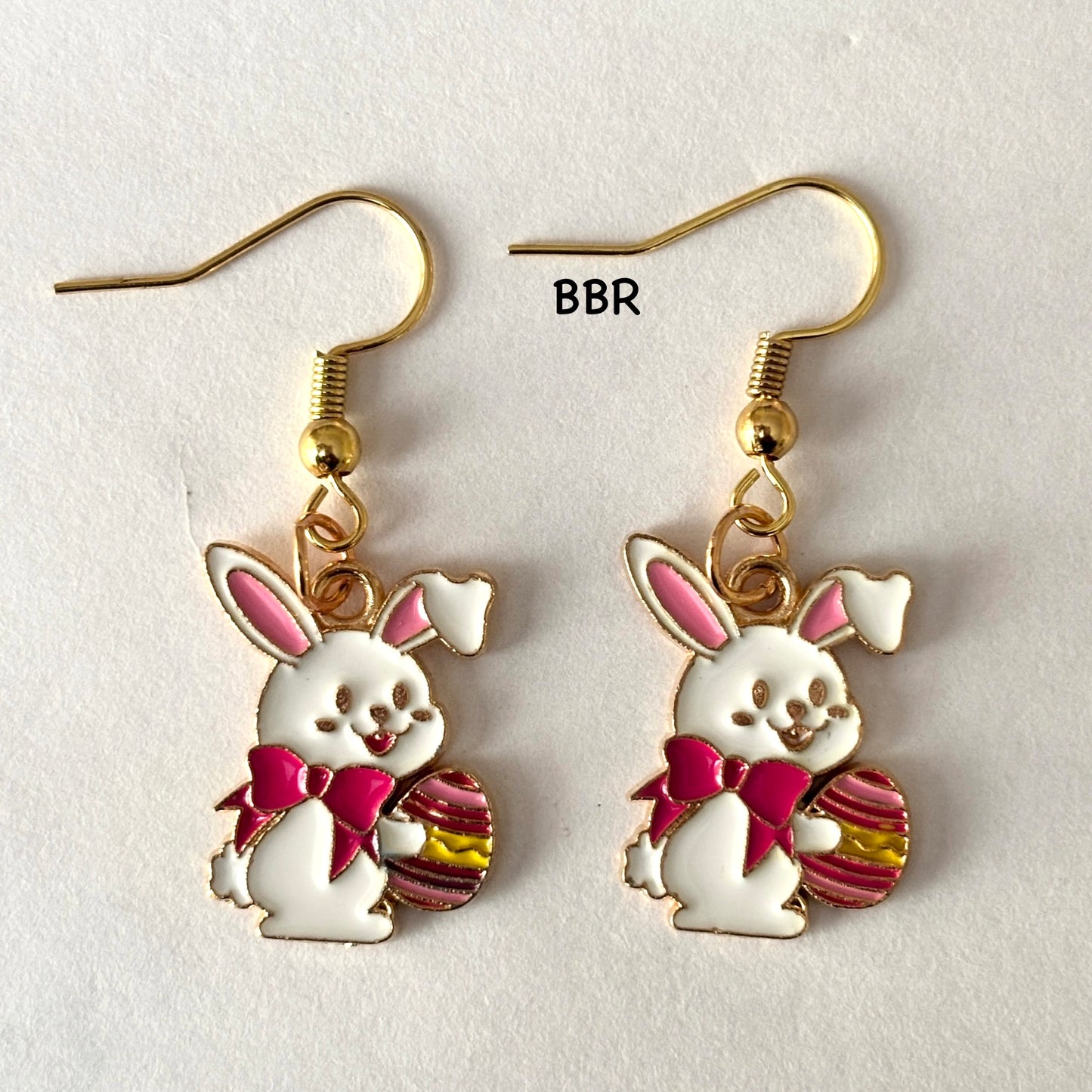 Bunny-shaped earrings with a pink bow and easter egg
