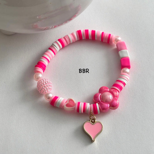 Handmade pink heishi clay bead bracelet with a pink heart charm.
