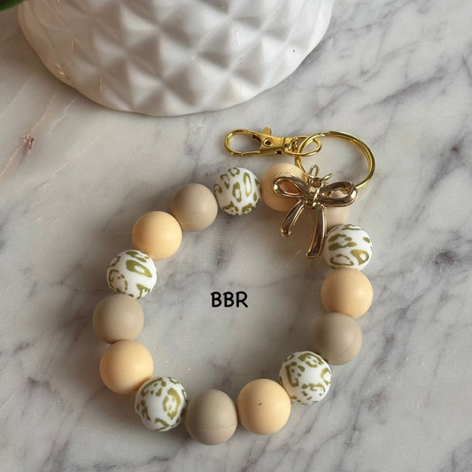 Wristlet beaded keychain with a gold bow charm.